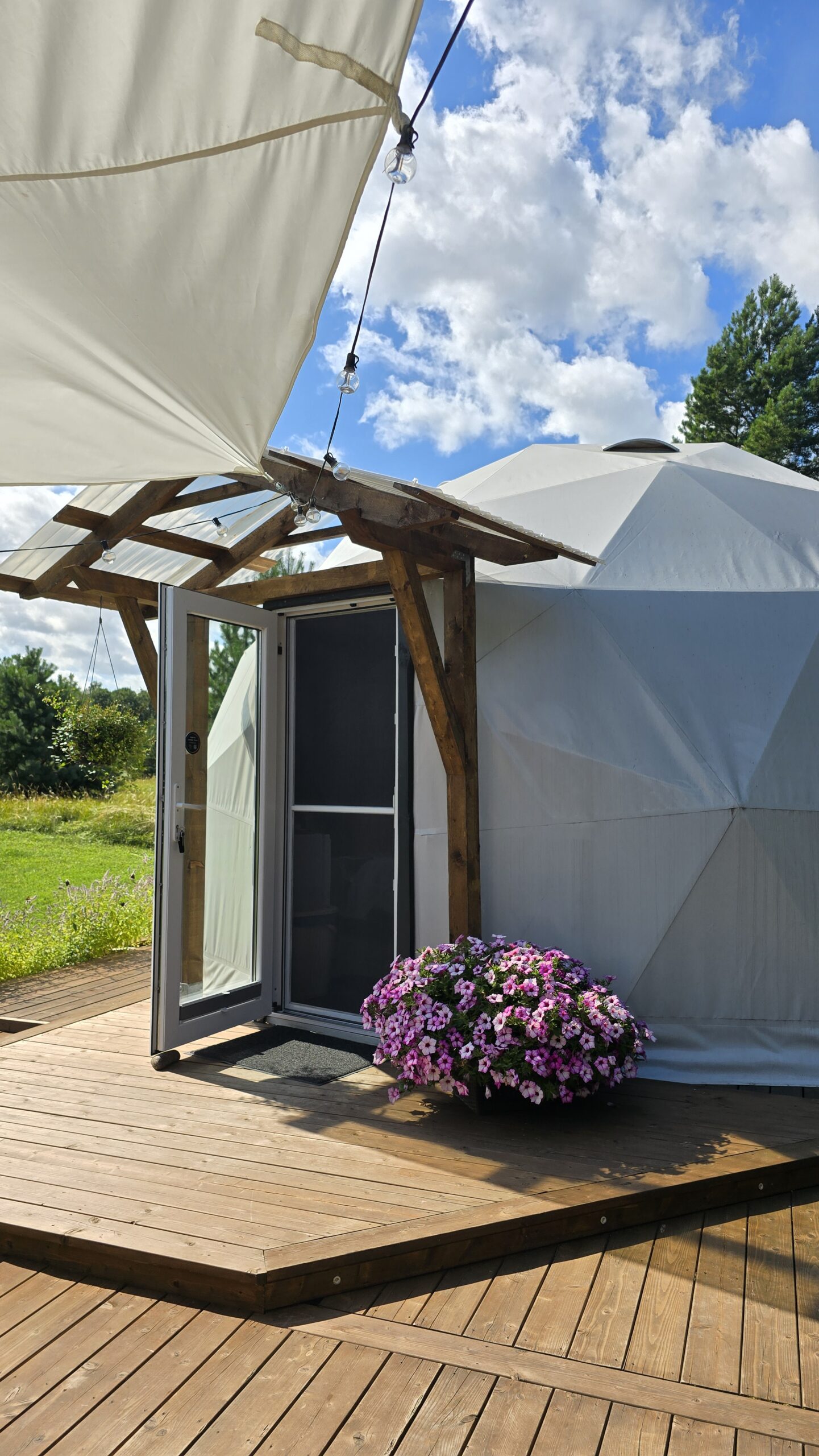 Kuppelmaja sissepääs ja lilledega terrass